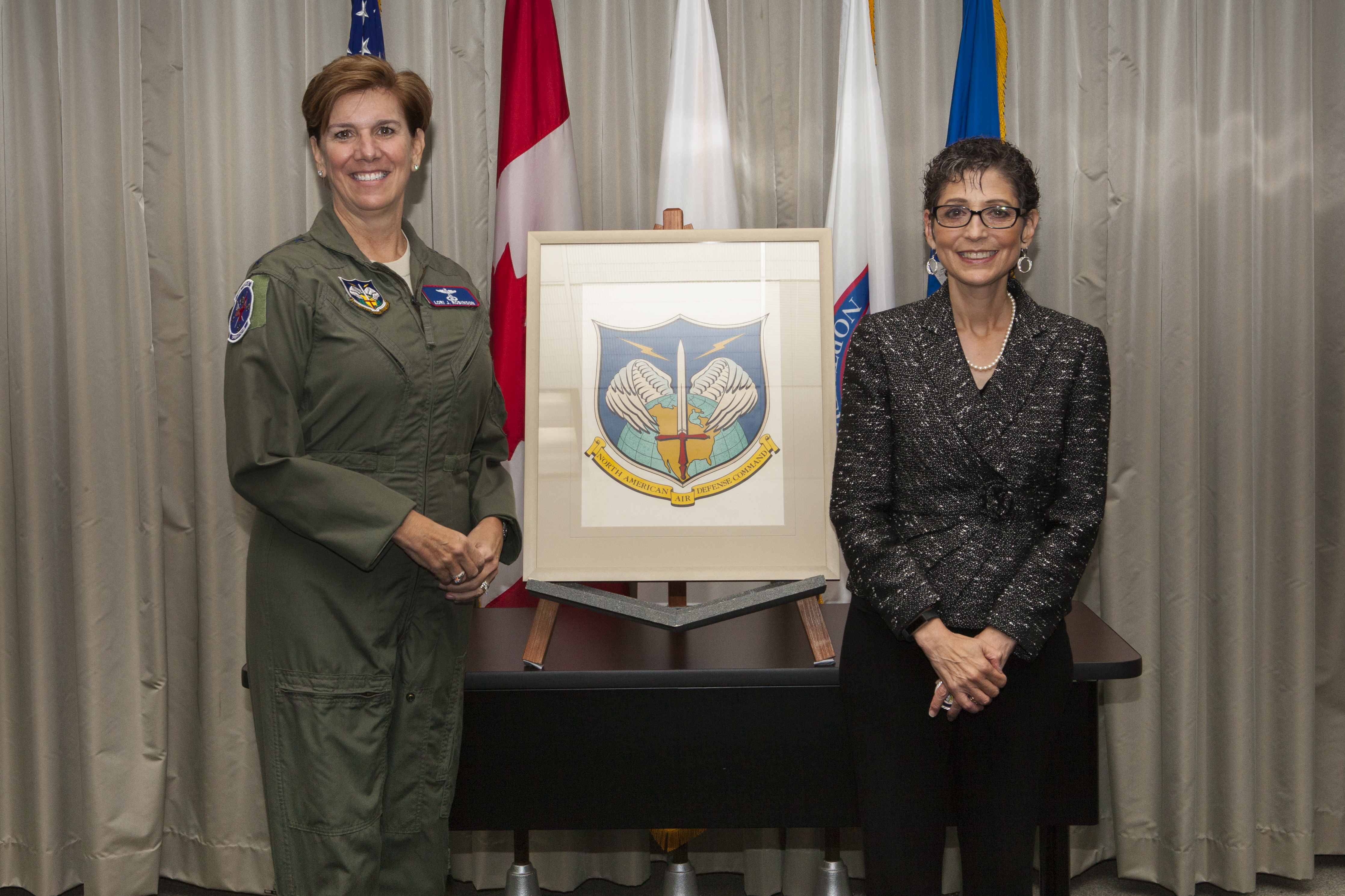 Gen. Robinson and Ms. Mona Rowe pose with original NORAD emblem art